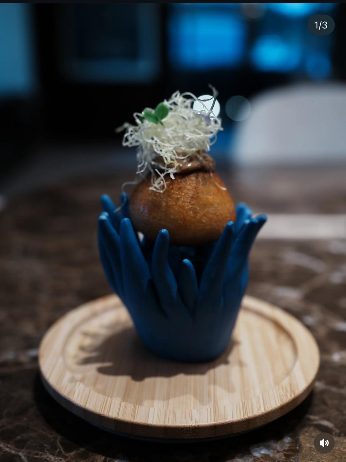 Signature amuse-bouche on a sculpted ceramic hand