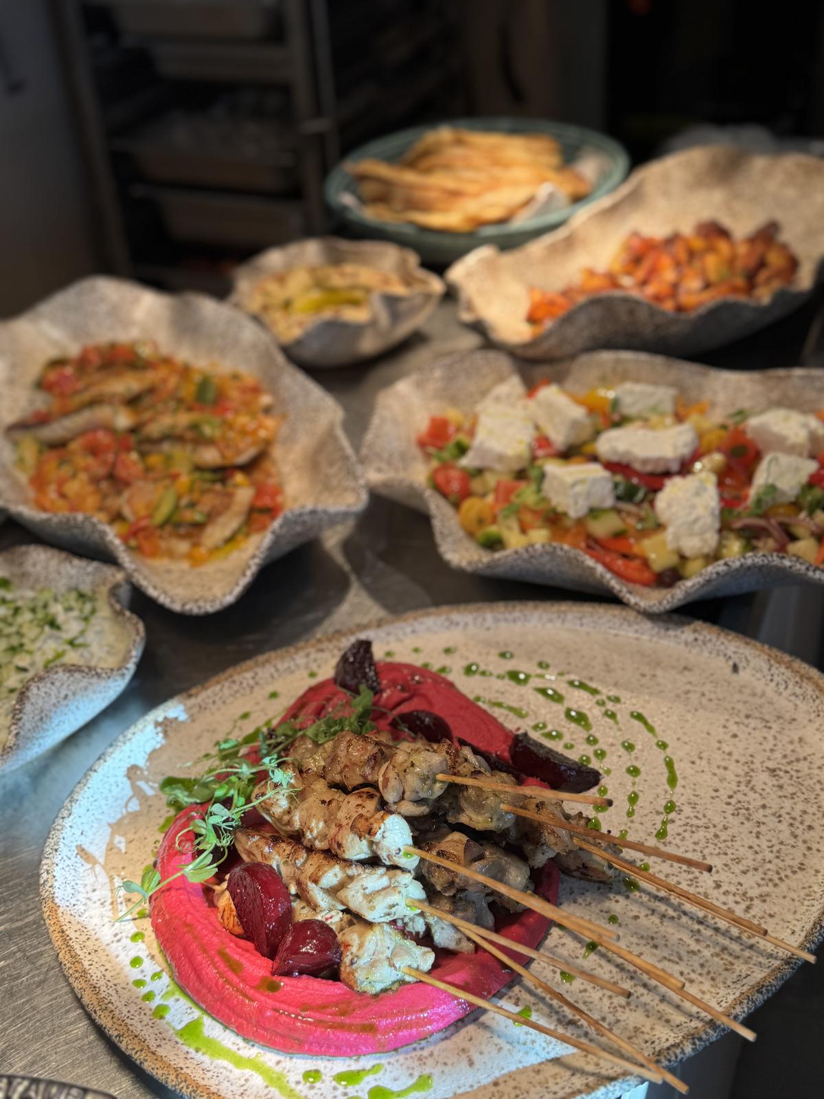 Mediterranean spread of skewers and vegetable bowls