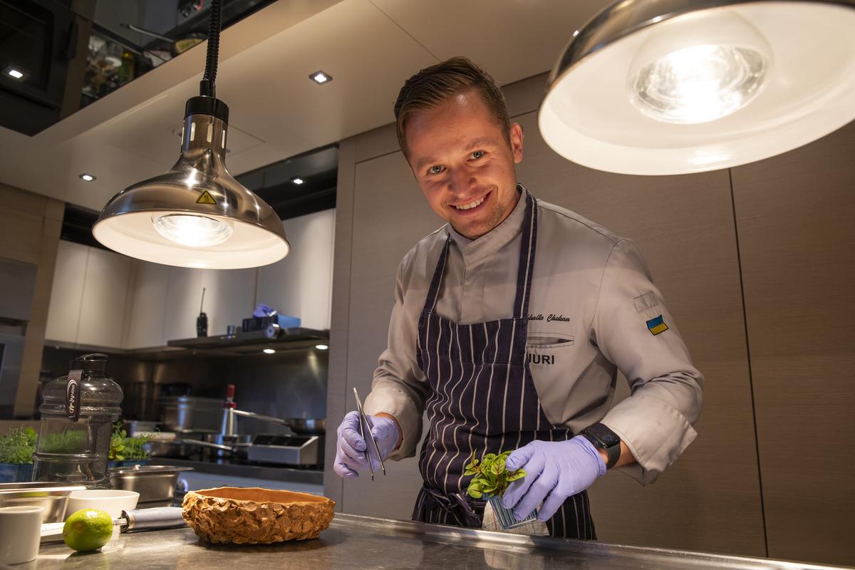 Chef Mykhailo plating a herb garnish at the MYBA Superyacht Chefs Competition 2024